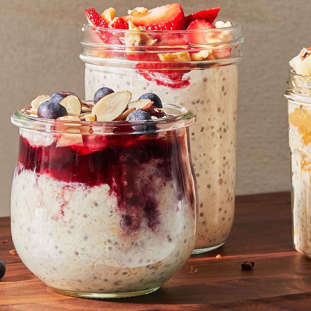 over night oats in a glass jar topped with various berries and nuts